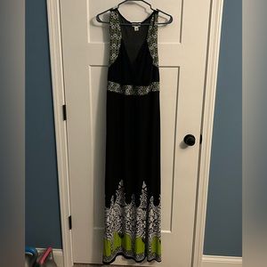 Black sleeveless dress with green & white designs. Ties in back